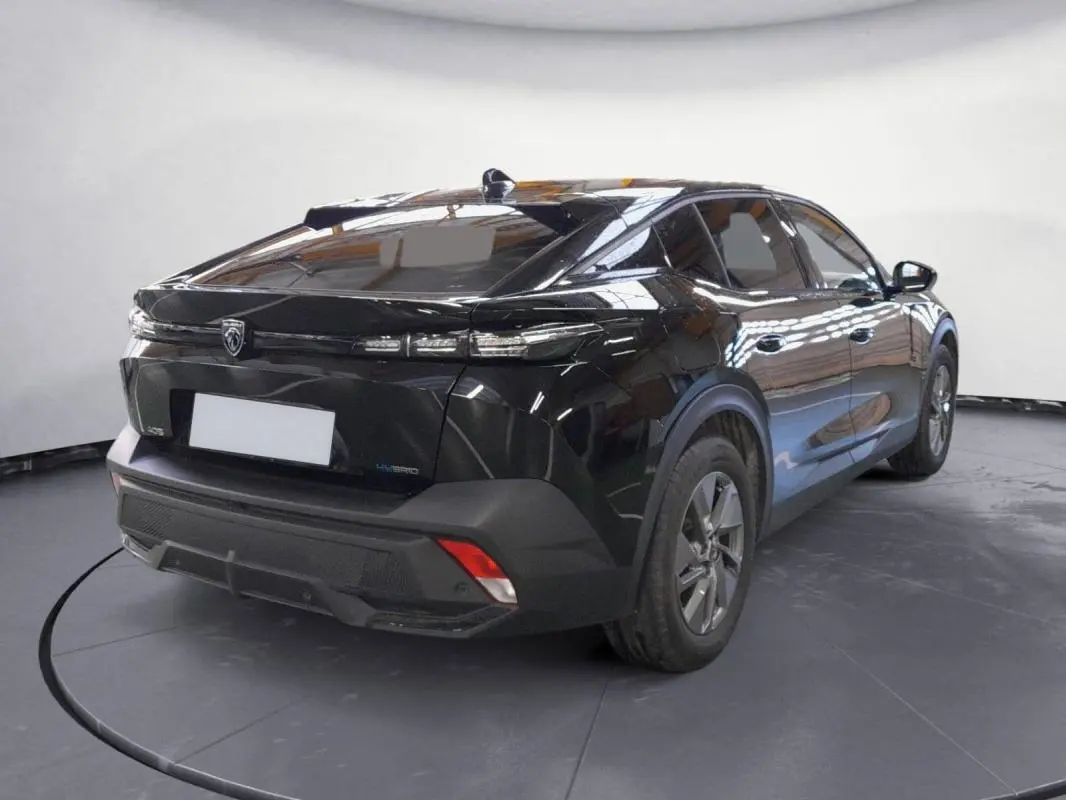 Vue 3/4 arrière droite d'une Peugeot 408 PHEV 180 e-EAT8 Allure noire avec jantes alliage et feux arrière effilés.