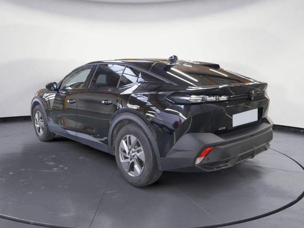 Vue 3/4 arrière droite d'une Peugeot 408 PHEV 180 noire avec jantes alliage 17 pouces et feux arrière LED distinctifs.
