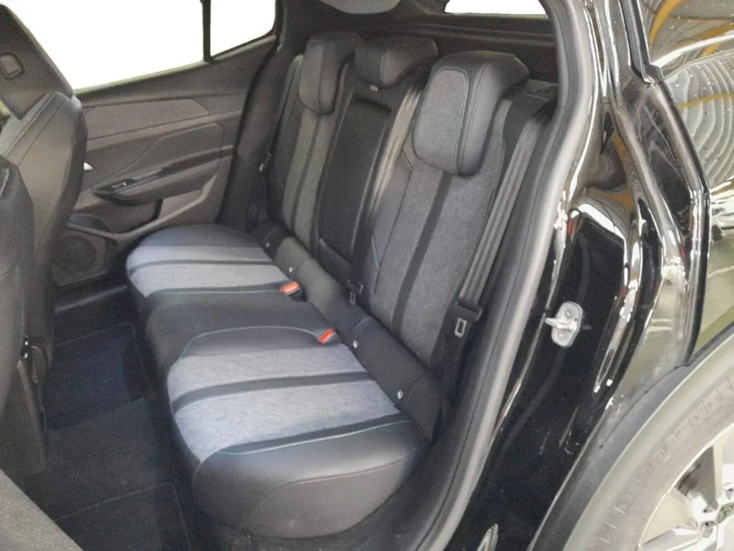 Vue intérieure arrière côté droit des sièges arrière bicolores gris et noir du Peugeot 408 PHEV 180 e-EAT8 Allure noir 2024.
