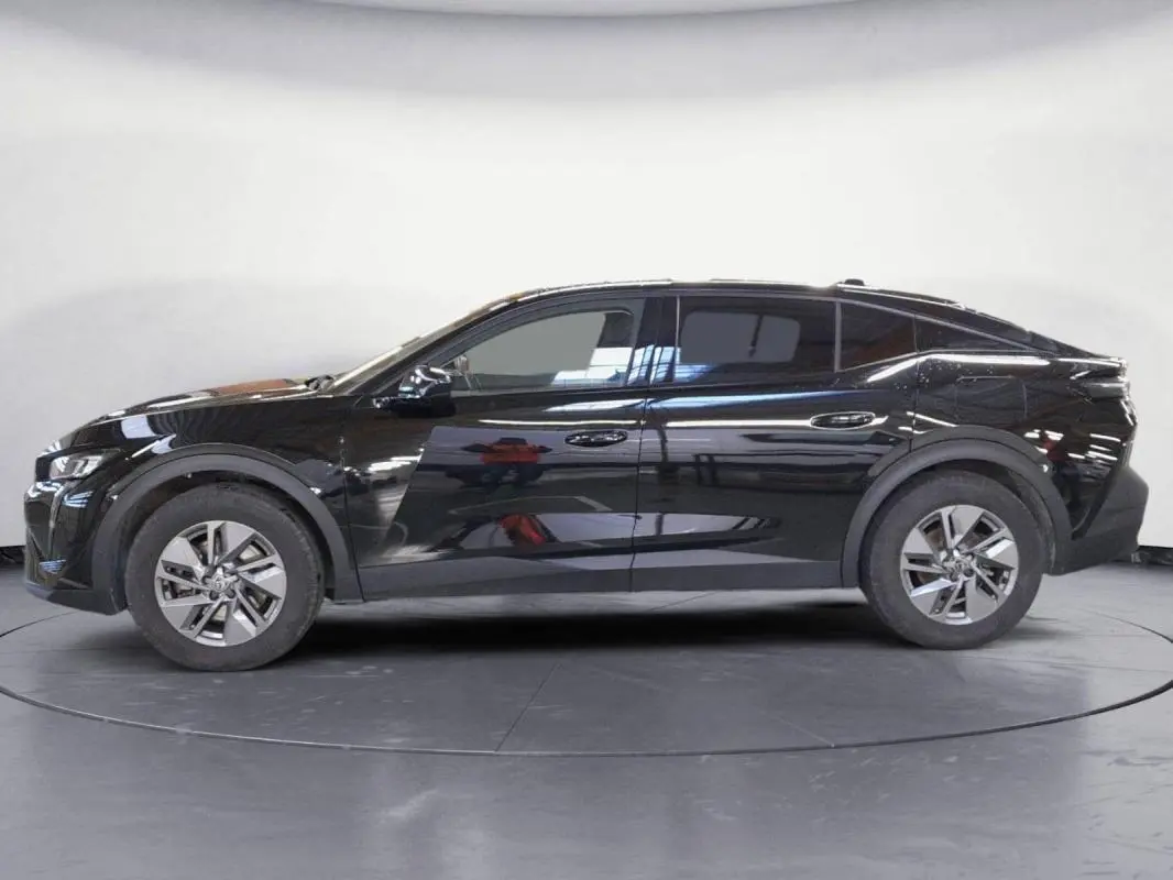Profil droit d'une Peugeot 408 PHEV 180 e-EAT8 Allure noire de 2024 avec jantes alliage 17 pouces et vitres teintées.