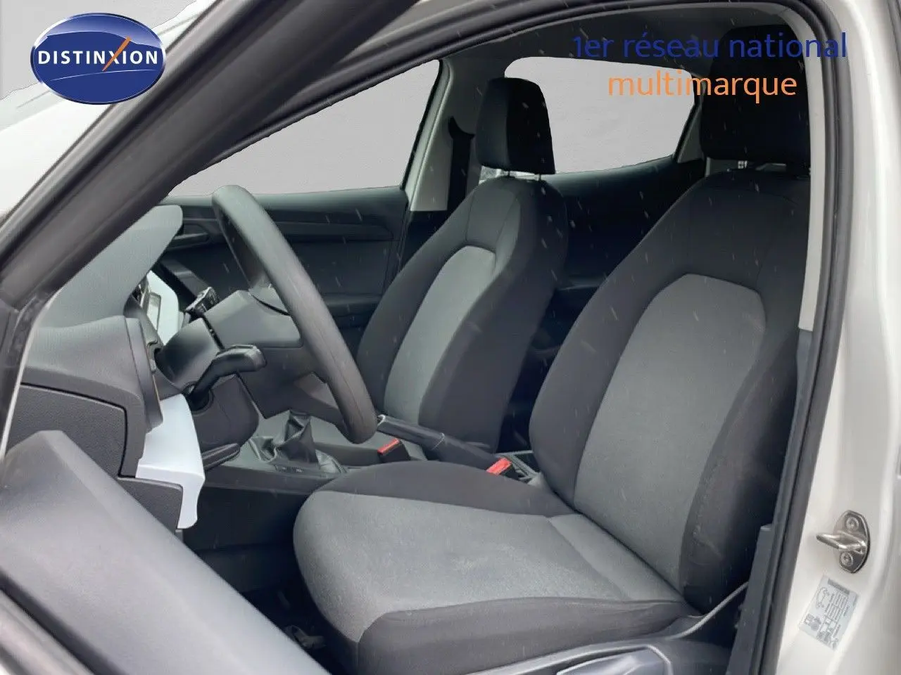 Vue intérieure côté gauche de la SEAT Ibiza blanche Candy 2021, mettant en valeur les sièges tissu noirs et le volant multifonction.