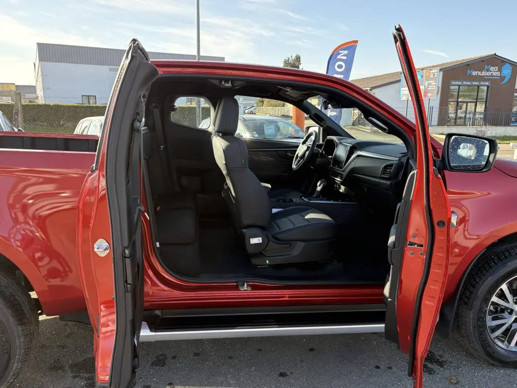 Vue latérale gauche du pick-up Isuzu D-MAX orange 2026 avec portes ouvertes et intérieur visible.