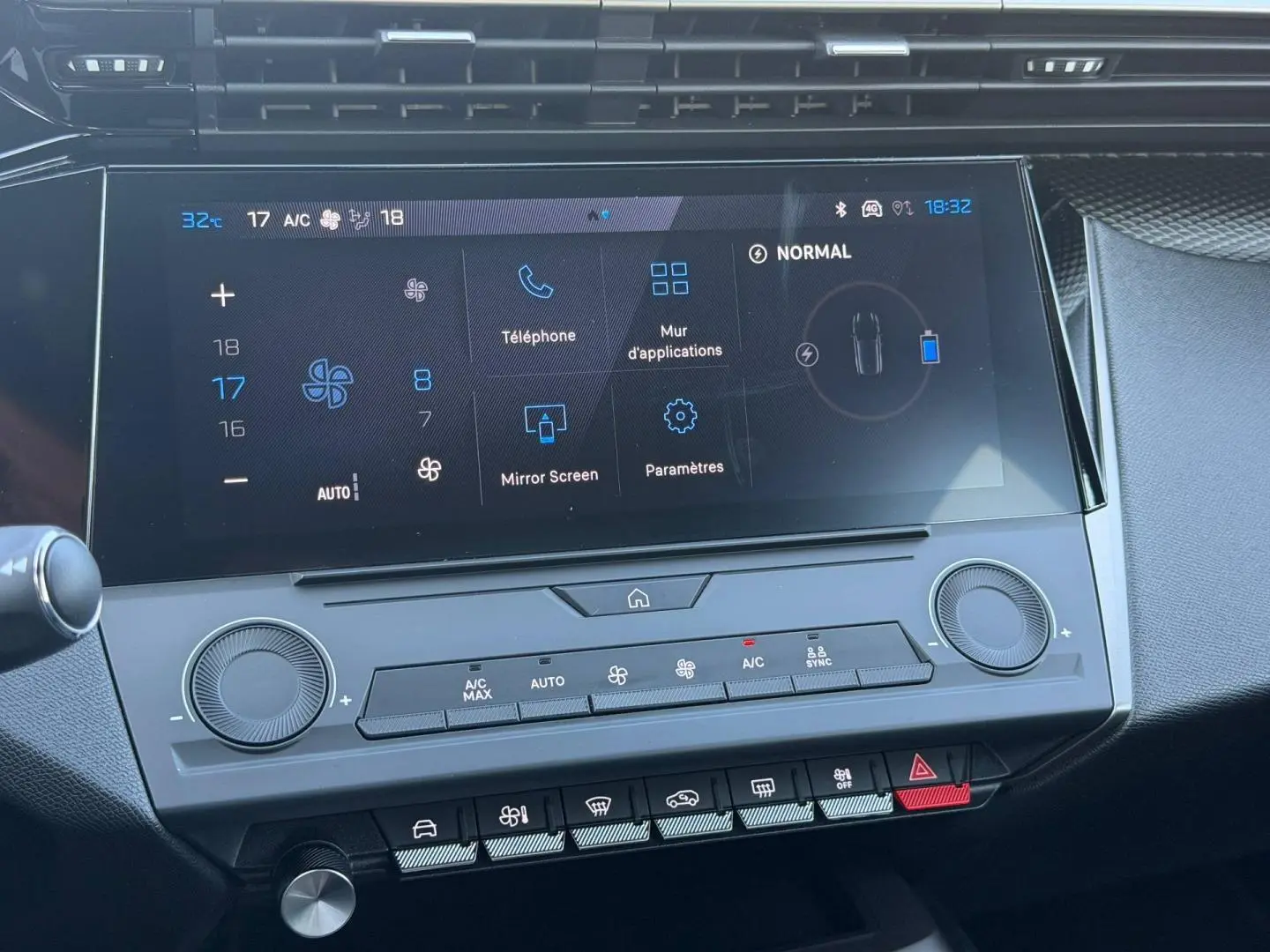 Écran tactile central et commandes climatisation de la Peugeot e-308 2025 en intérieur noir.