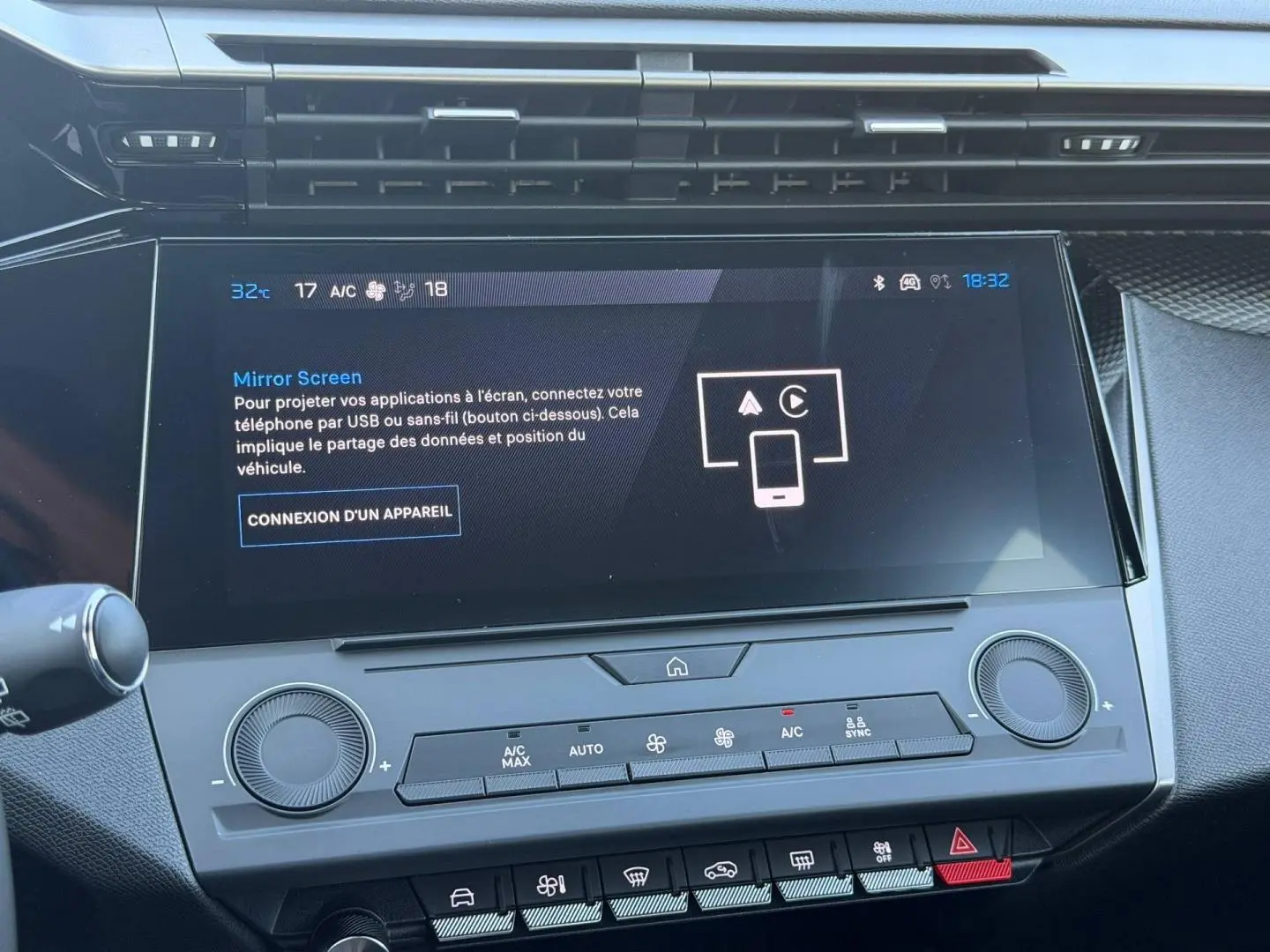 Vue rapprochée de l’écran tactile central et des commandes de climatisation de la Peugeot e-308 noire, intérieur moderne et épuré.