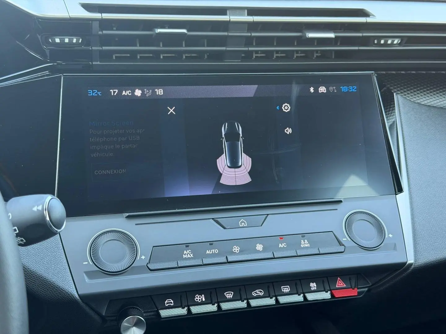 Vue rapprochée de l’écran tactile central et des commandes de climatisation de la Peugeot e-308 2025 noir Perla Nera.