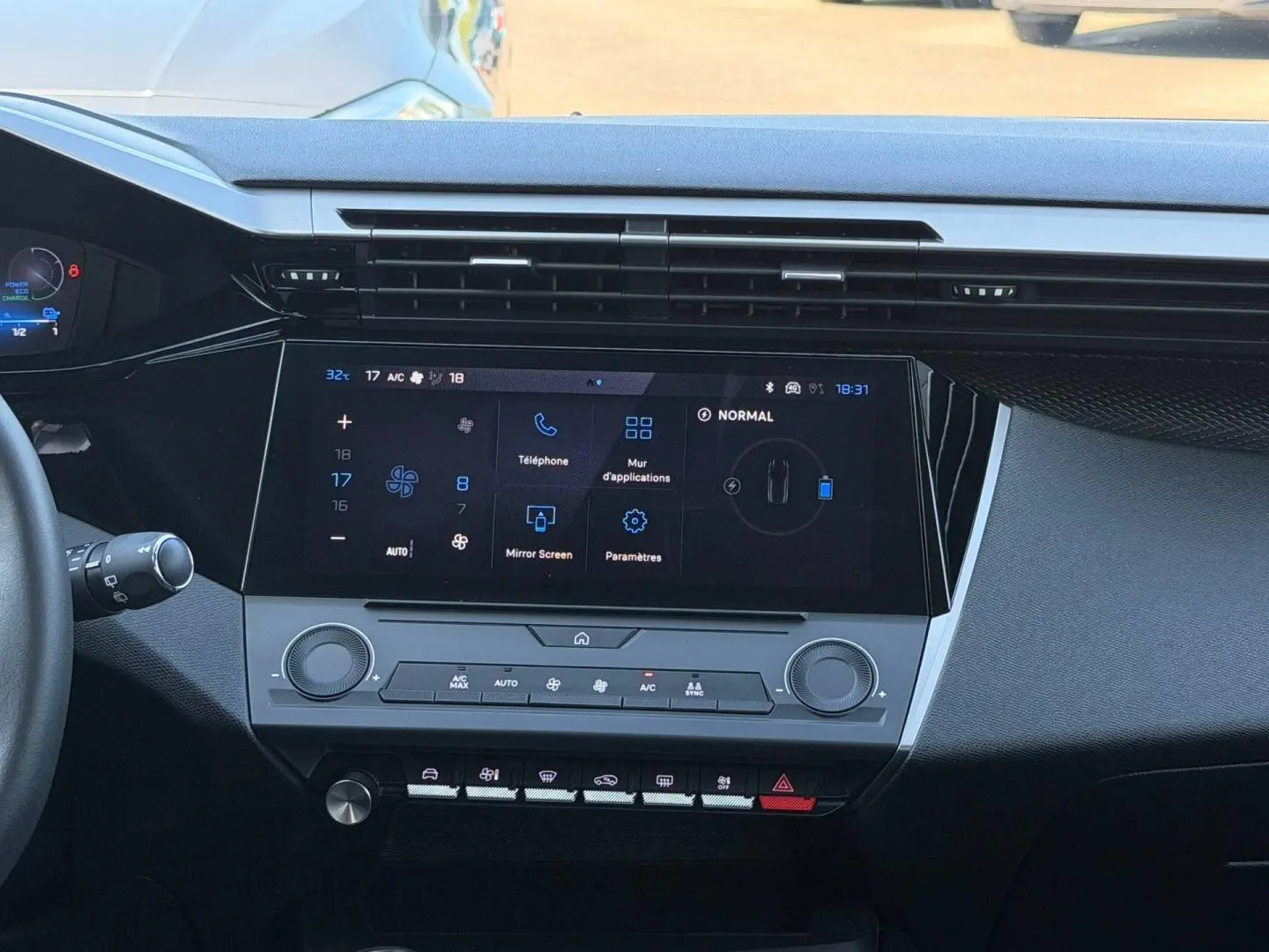 Vue intérieure centrée sur la console centrale tactile et les commandes de climatisation du Peugeot e-308 noir Perla Nera.