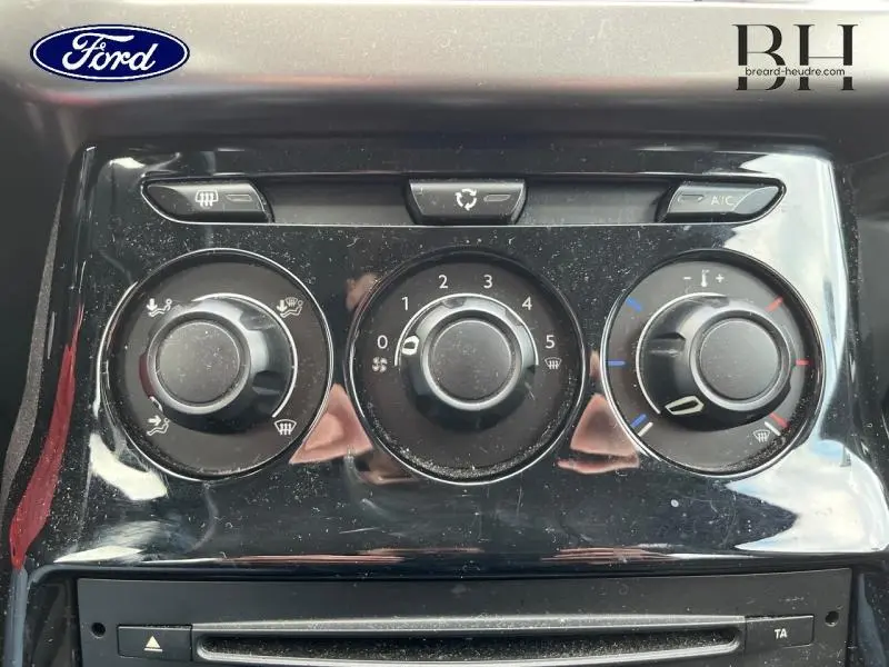 Panneau de commande de climatisation noir brillant de la CITROEN C3 bleu encre, vue rapprochée sur les boutons rotatifs.