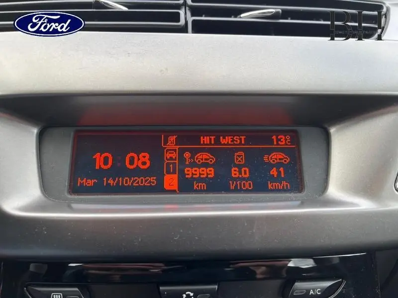 Affichage central numérique rouge d'une Citroën C3 bleu encre, montrant heure, date et informations de conduite