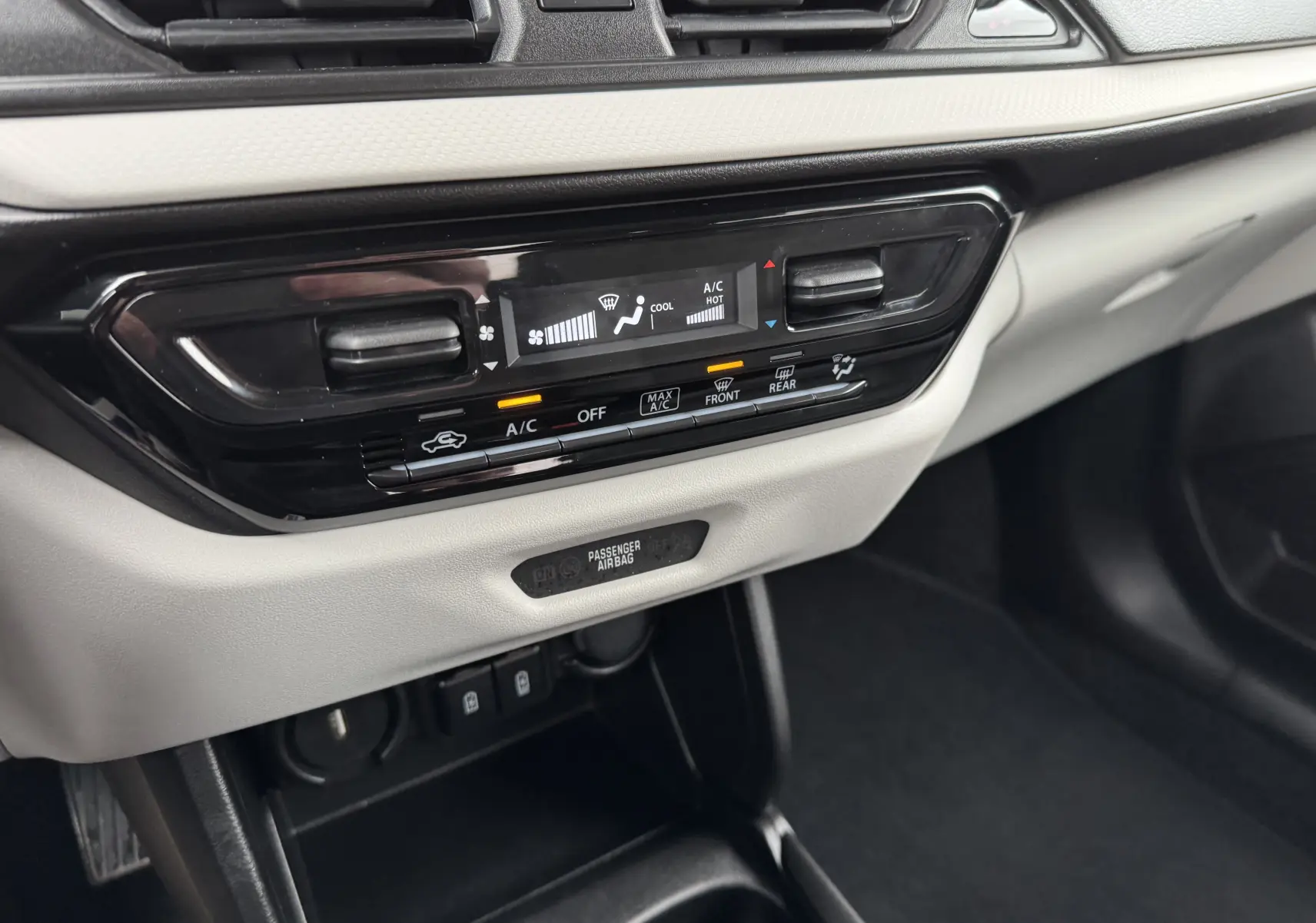 Détail de la console centrale de la Suzuki Swift 1.2 Privilege Hybrid 2025, montrant la climatisation automatique avec écran digital.