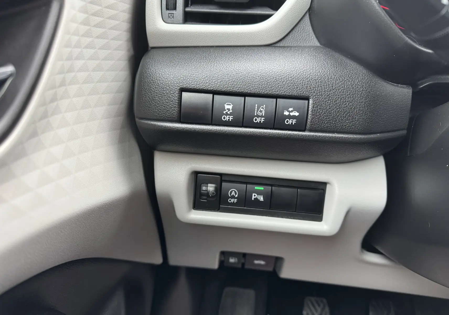 Gros plan sur les commandes de sécurité et assistance côté gauche du tableau de bord de la Suzuki Swift 1.2 Privilège Hybrid 2025.