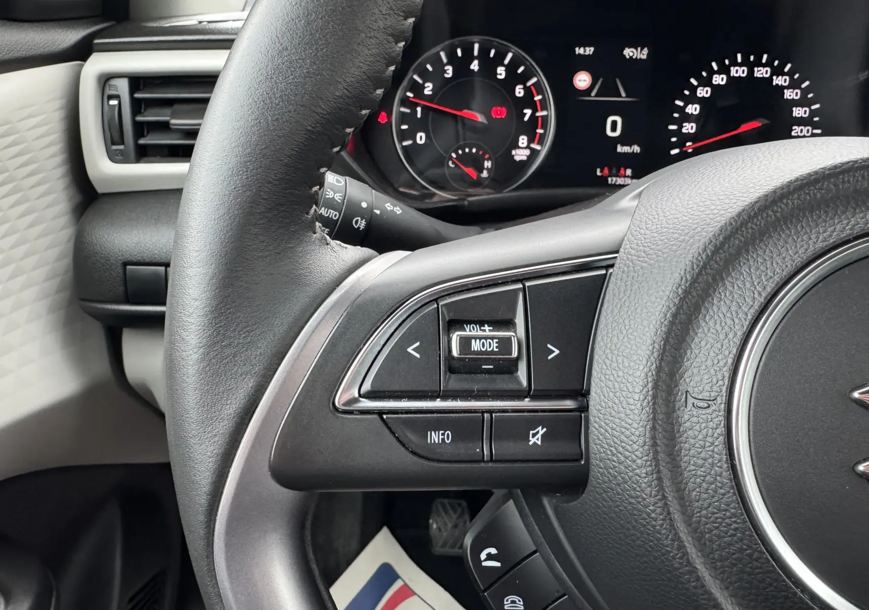 Gros plan sur le volant et le tableau de bord digital de la Suzuki Swift 1.2 Privilège Hybrid 2025, intérieur noir.