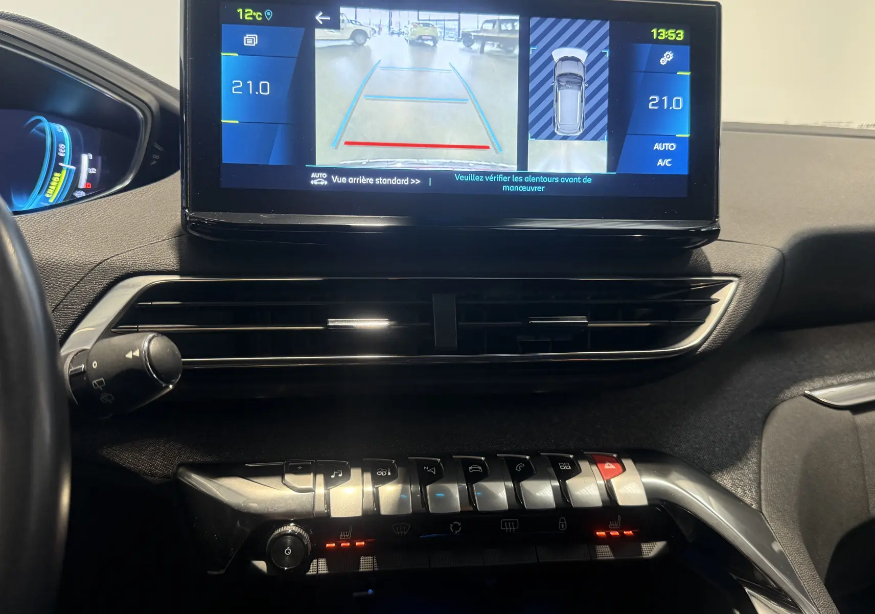 Vue intérieure du tableau de bord du Peugeot 3008 Hybrid rouge 2025, avec écran tactile affichant la caméra de recul.