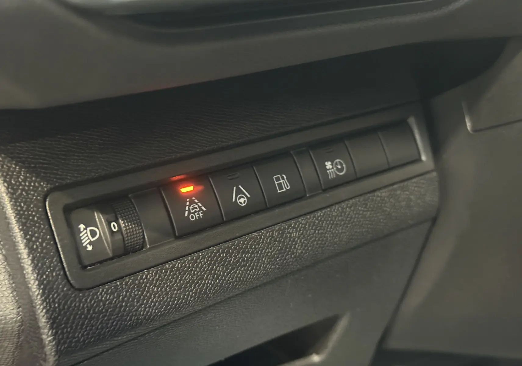 Gros plan sur les commandes intérieures du tableau de bord du Peugeot 3008 Hybrid 2025, avec témoin d’alerte activé.