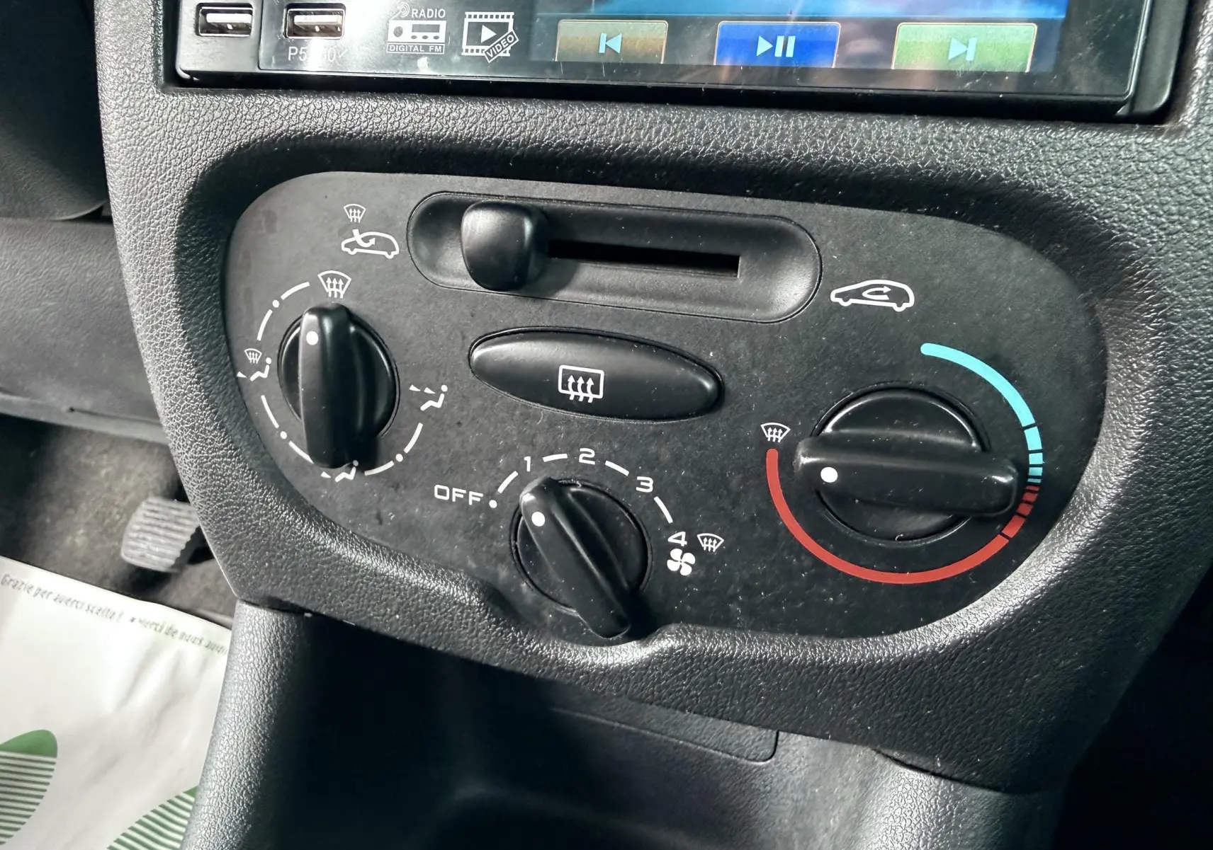 Gros plan sur l’autoradio MP5 avec écran tactile dans l’habitacle d’une Peugeot 206+ bleu.