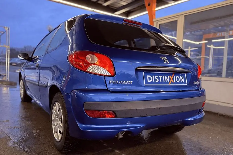 Profil latéral droit d'une Peugeot 206+ bleue à trois portes, avec poignées et protections noires visibles.