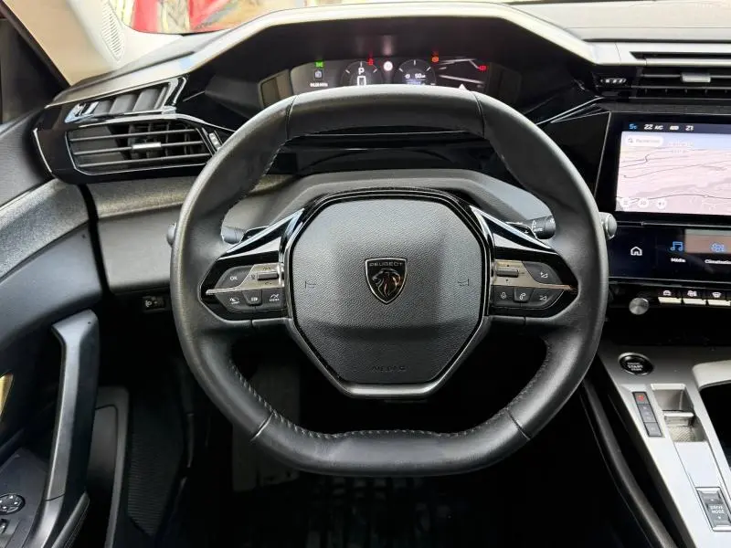 Vue frontale du volant noir du Peugeot 308 2024 avec tableau de bord numérique et écran tactile central.