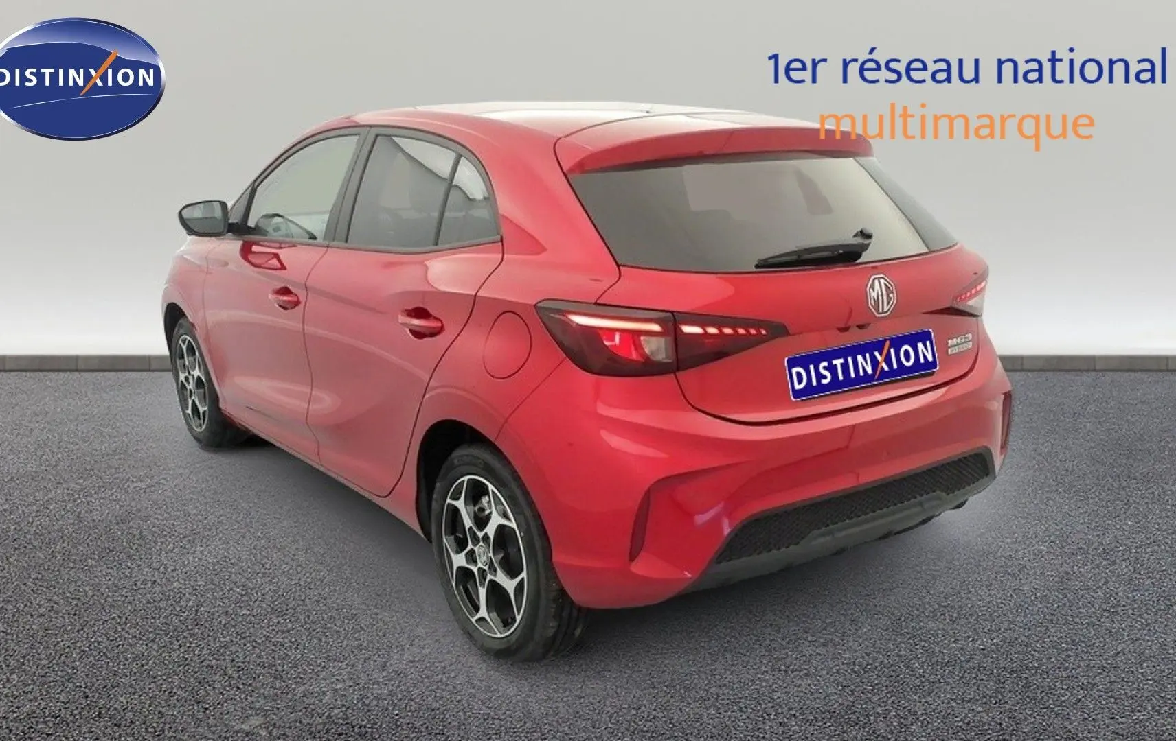 Vue 3/4 arrière droite d'une MG3 1.5 L Hybrid+ rouge Diamond avec jantes alliage et feux LED allumés.