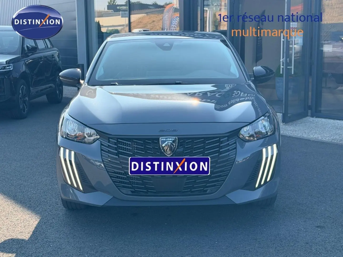 Vue de face d'une Peugeot 208 1.2 100ch S&S Allure gris Artense avec feux diurnes LED en griffes distinctives.