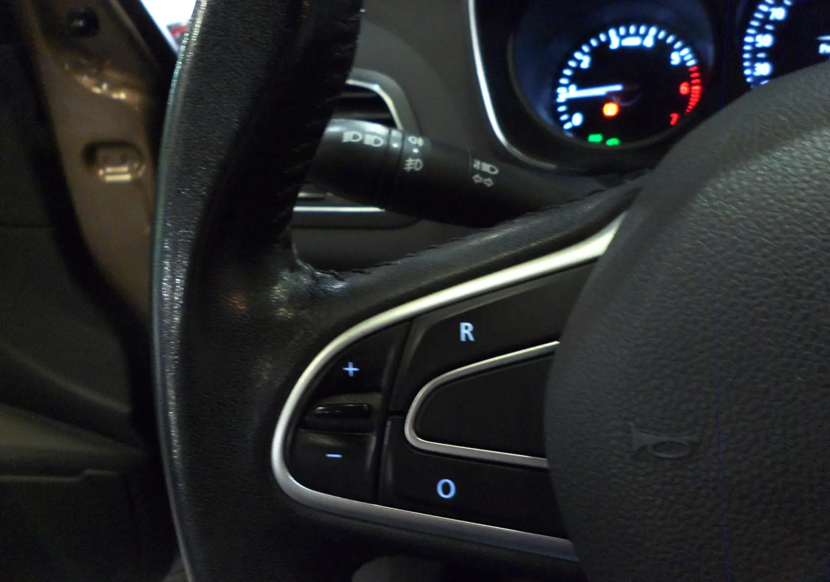 Vue intérieure centrée sur le volant noir d’une Renault Mégane IV brun capuccino, avec tableau de bord et console centrale visibles.