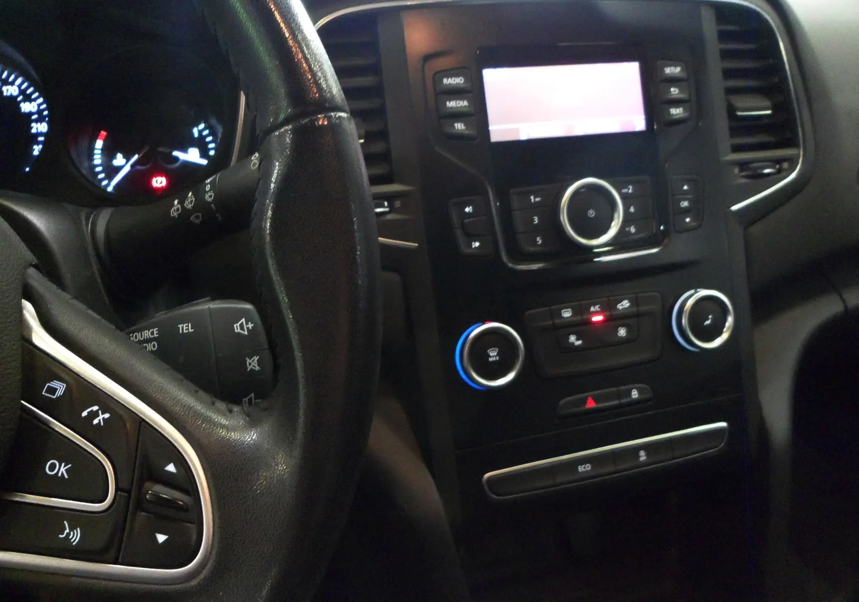 Vue intérieure côté conducteur de la Renault Mégane IV brun cappuccino, montrant les sièges tissu et la boîte manuelle.