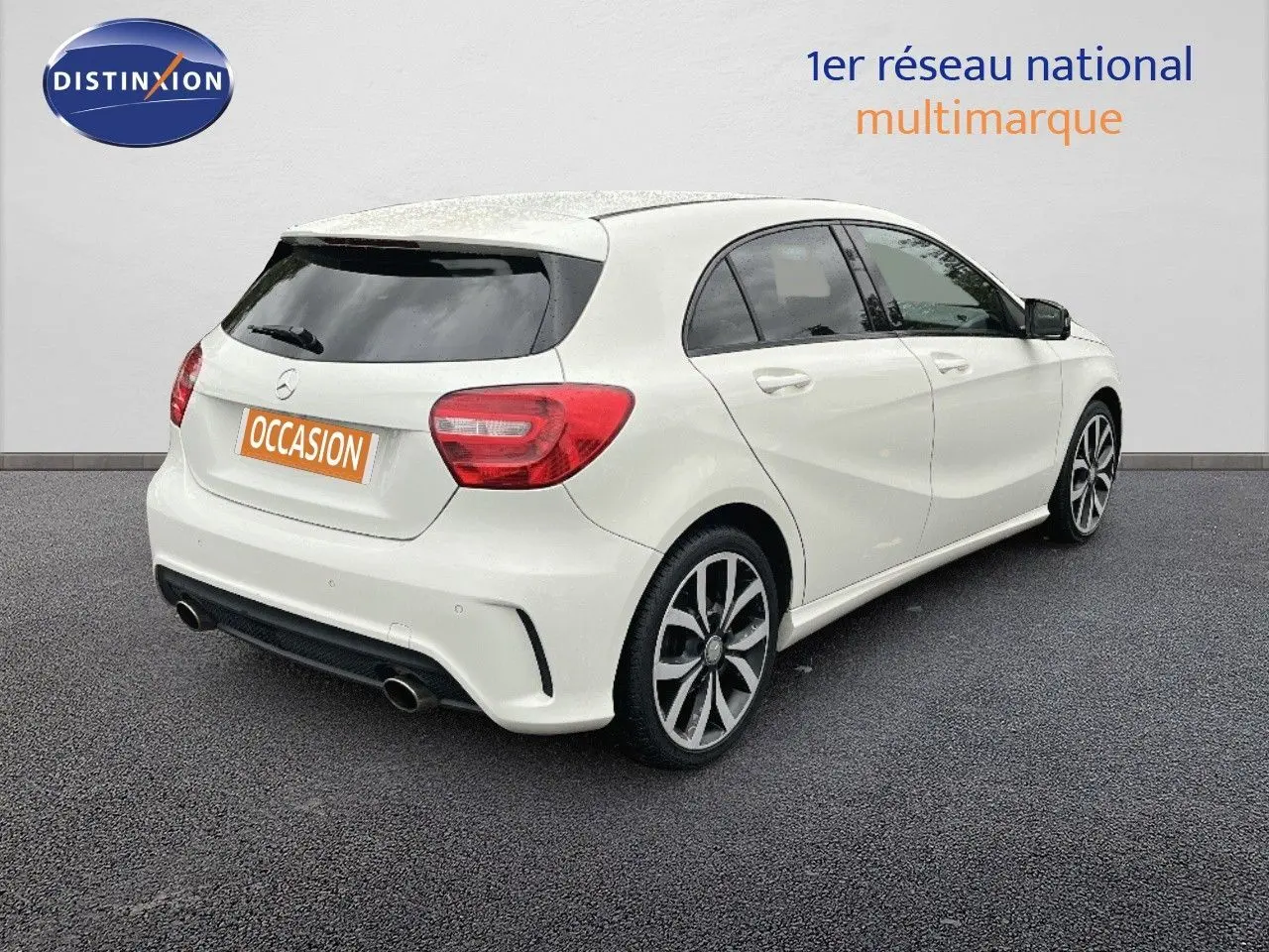 Vue 3/4 arrière droite d'une Mercedes Classe A 180 Sensation blanche de 2013 avec jantes alliage et double sortie d'échappement.