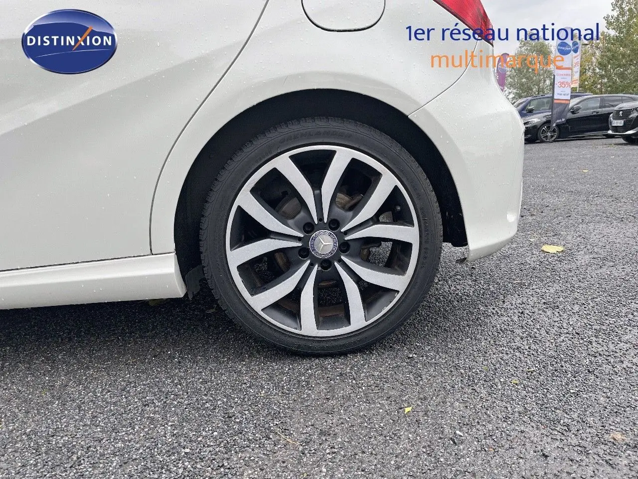 Gros plan sur la roue arrière droite d'une Mercedes Classe A 180 Sensation blanche de 2013, avec jante alliage distinctive.