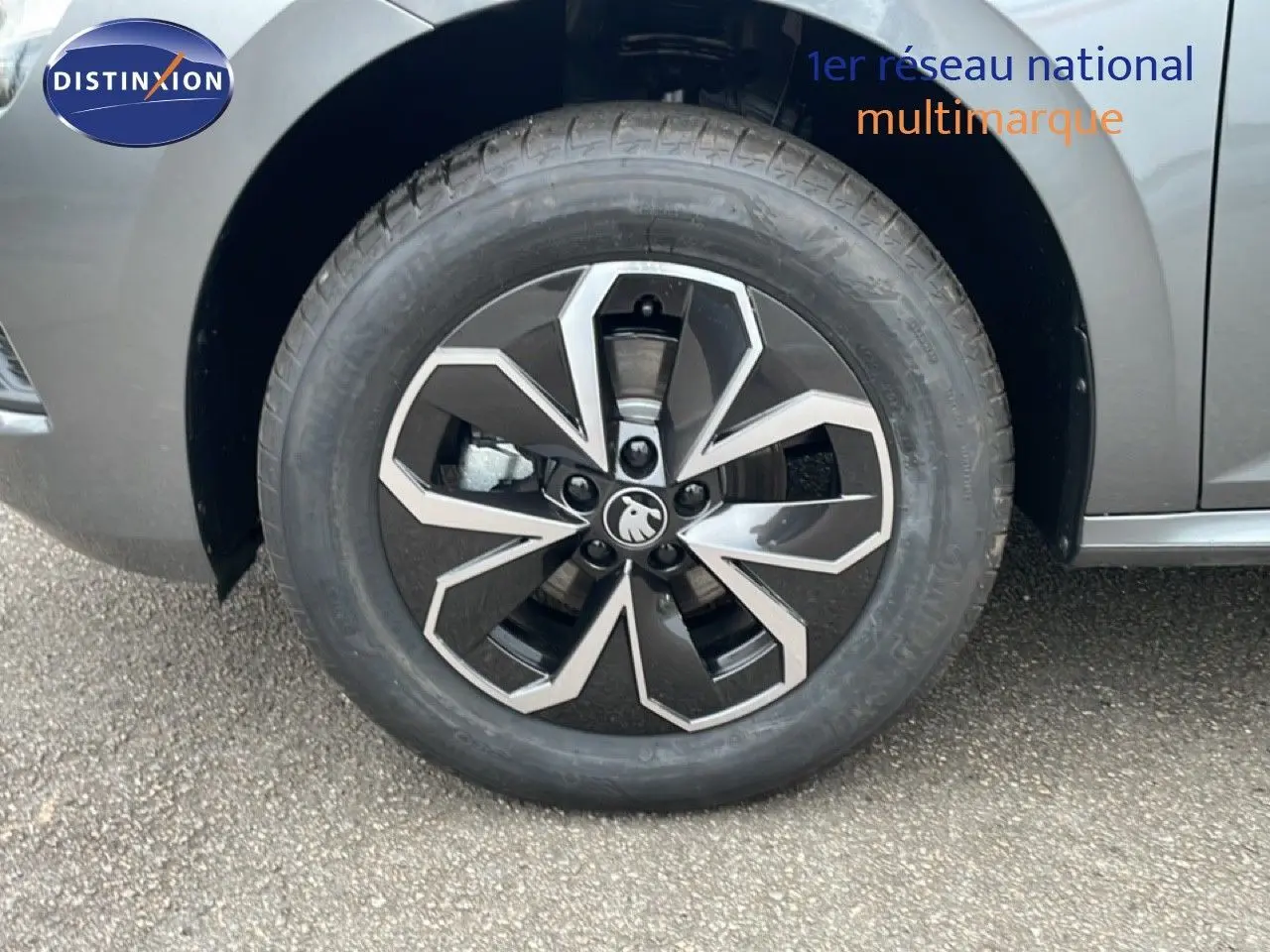 Gros plan sur la roue avant gauche d’un Skoda Kamiq gris graphite métal avec jante alliage noire et argentée.