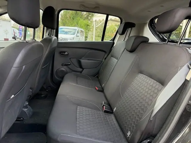 Vue intérieure côté droit montrant la banquette arrière noire avec sellerie Lauréate du Dacia Sandero 2015.