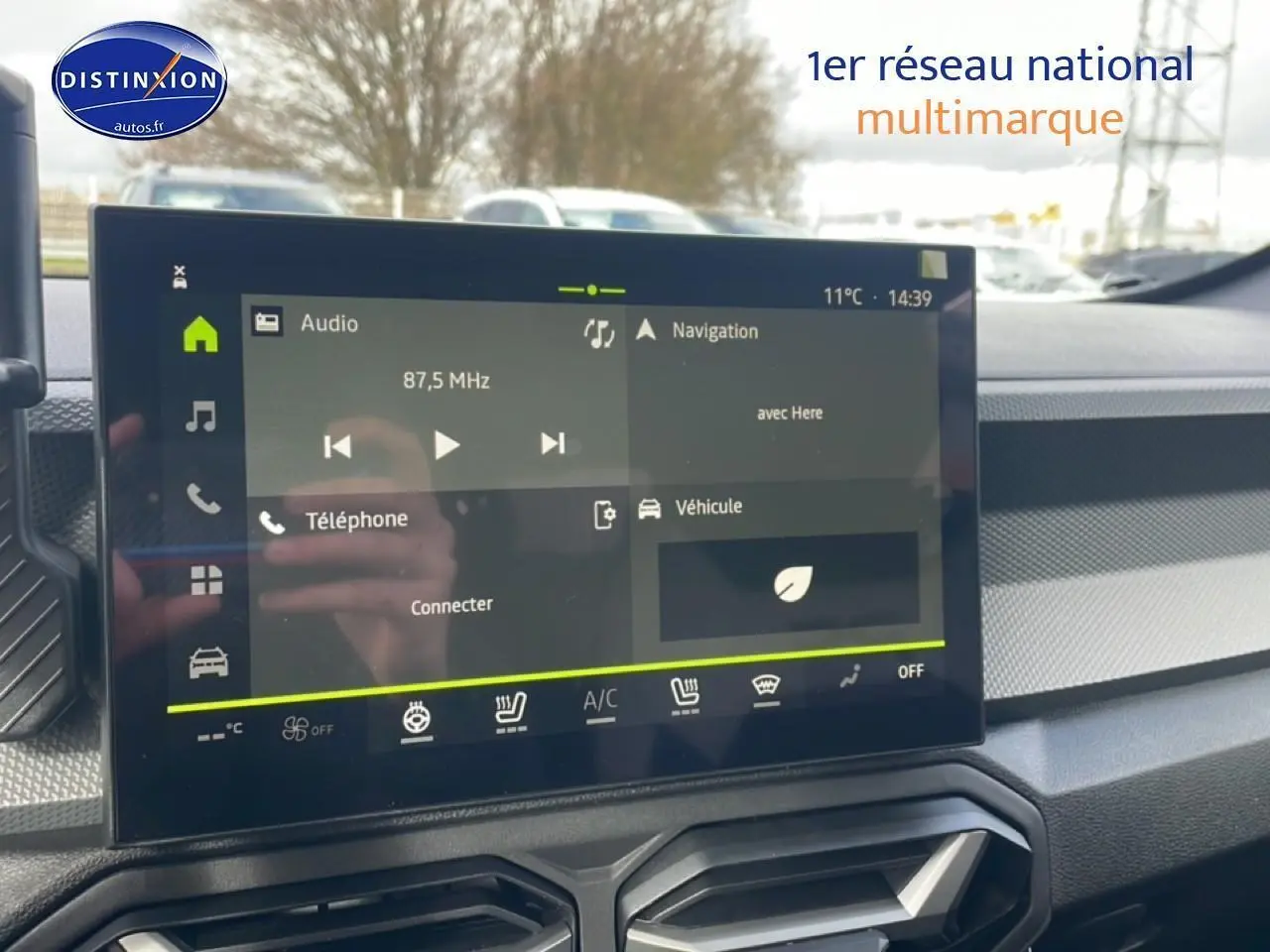 Écran tactile central du tableau de bord du Dacia Duster 2026, avec commandes clim et multimédia visibles.