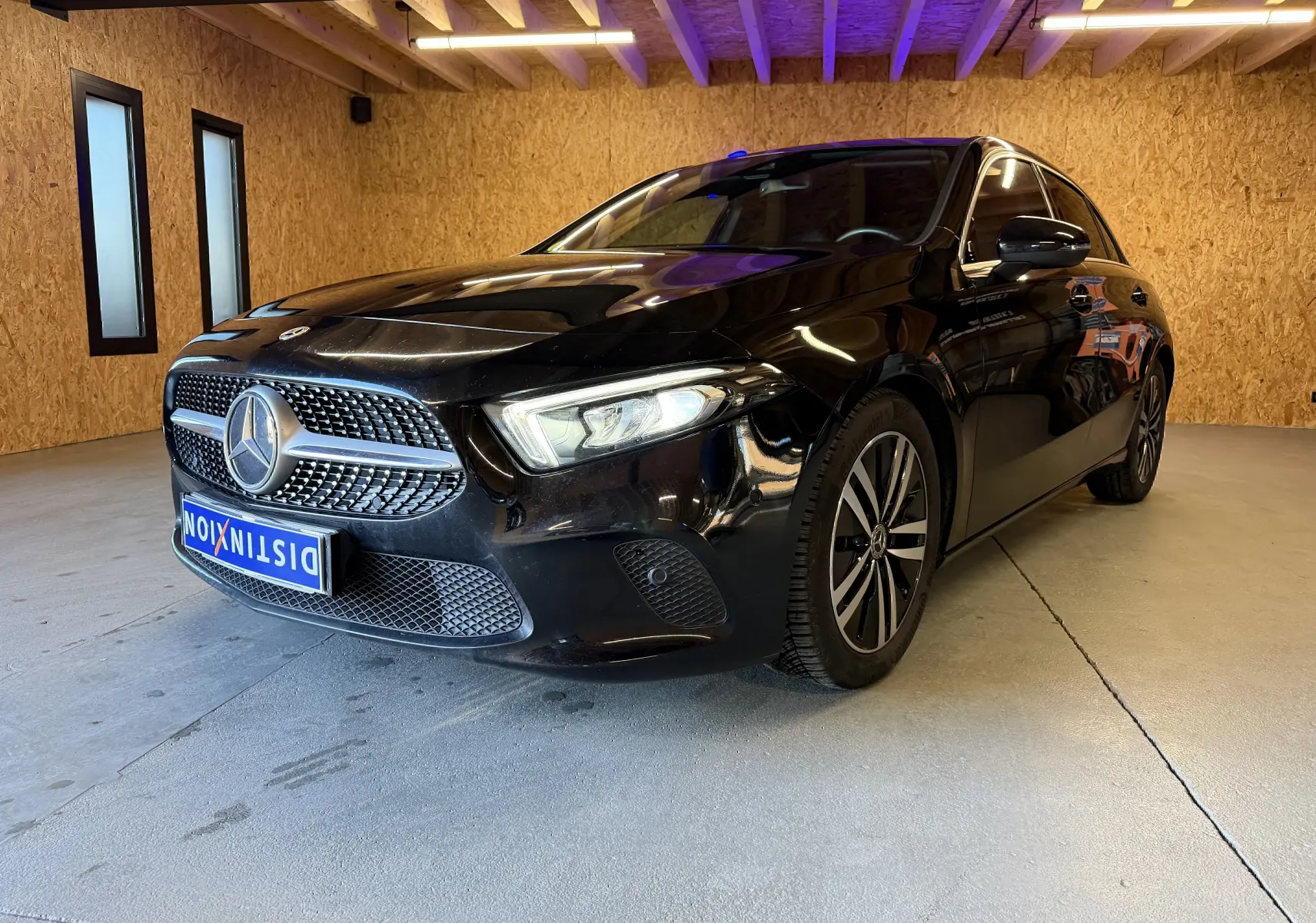 Mercedes Classe A noire vue en 3/4 avant droit, avec calandre étoile et jantes alliage distinctives.