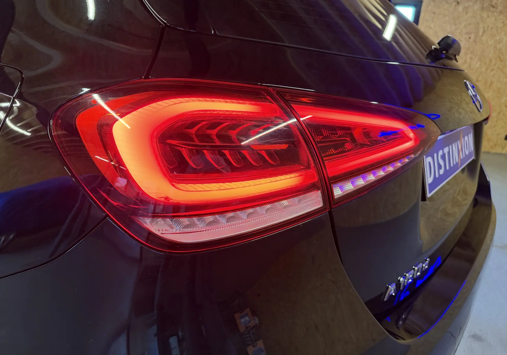 Feu arrière droit allumé d'une Mercedes Classe A noire vue en gros plan sur l'arrière du véhicule.