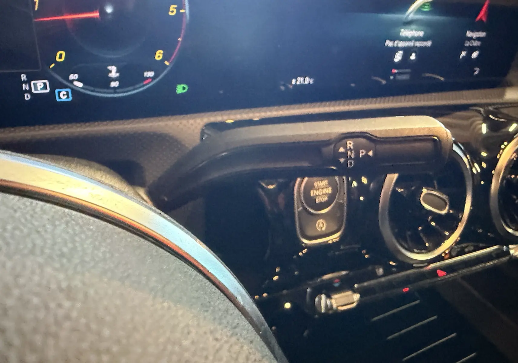 Gros plan sur le tableau de bord noir de la Mercedes Classe A 2022, avec levier de vitesses et bouton start/stop visibles.