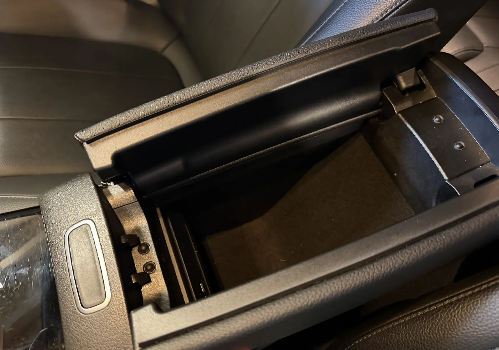 Vue rapprochée de l'accoudoir central noir ouvert de la Mercedes Classe A 2022 avec intérieur en similicuir noir.