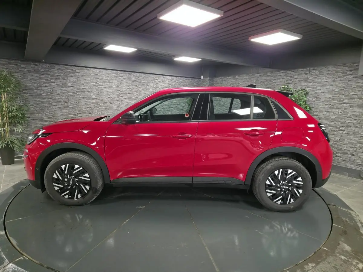 Vue de profil côté gauche du FIAT 600 1.2 Hybrid rouge avec jantes acier bicolores et coques de rétroviseurs noires.