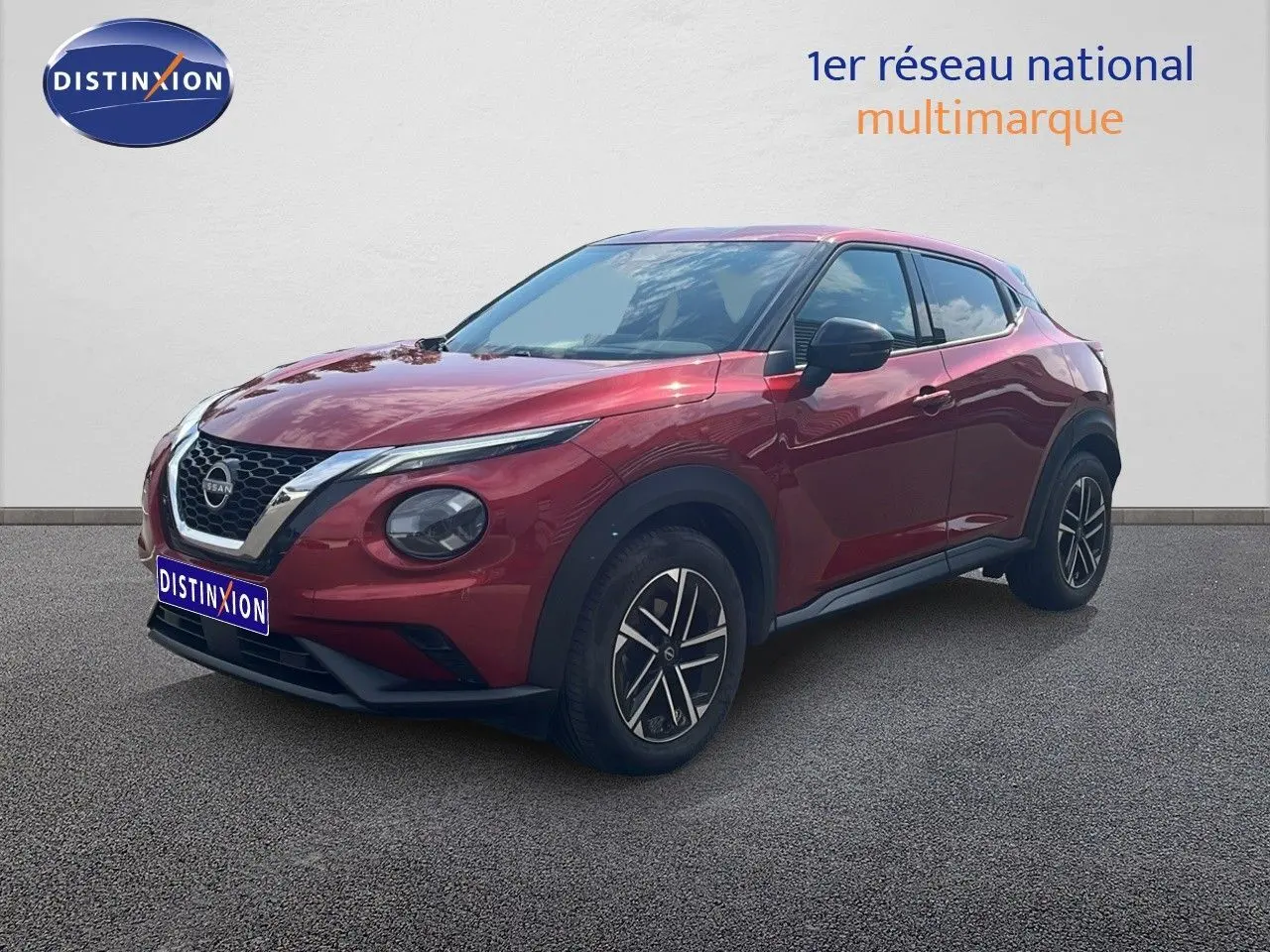 Nissan Juke rouge Fuji Metal en 3/4 avant droit, avec jantes alliage et calandre chromée visible.