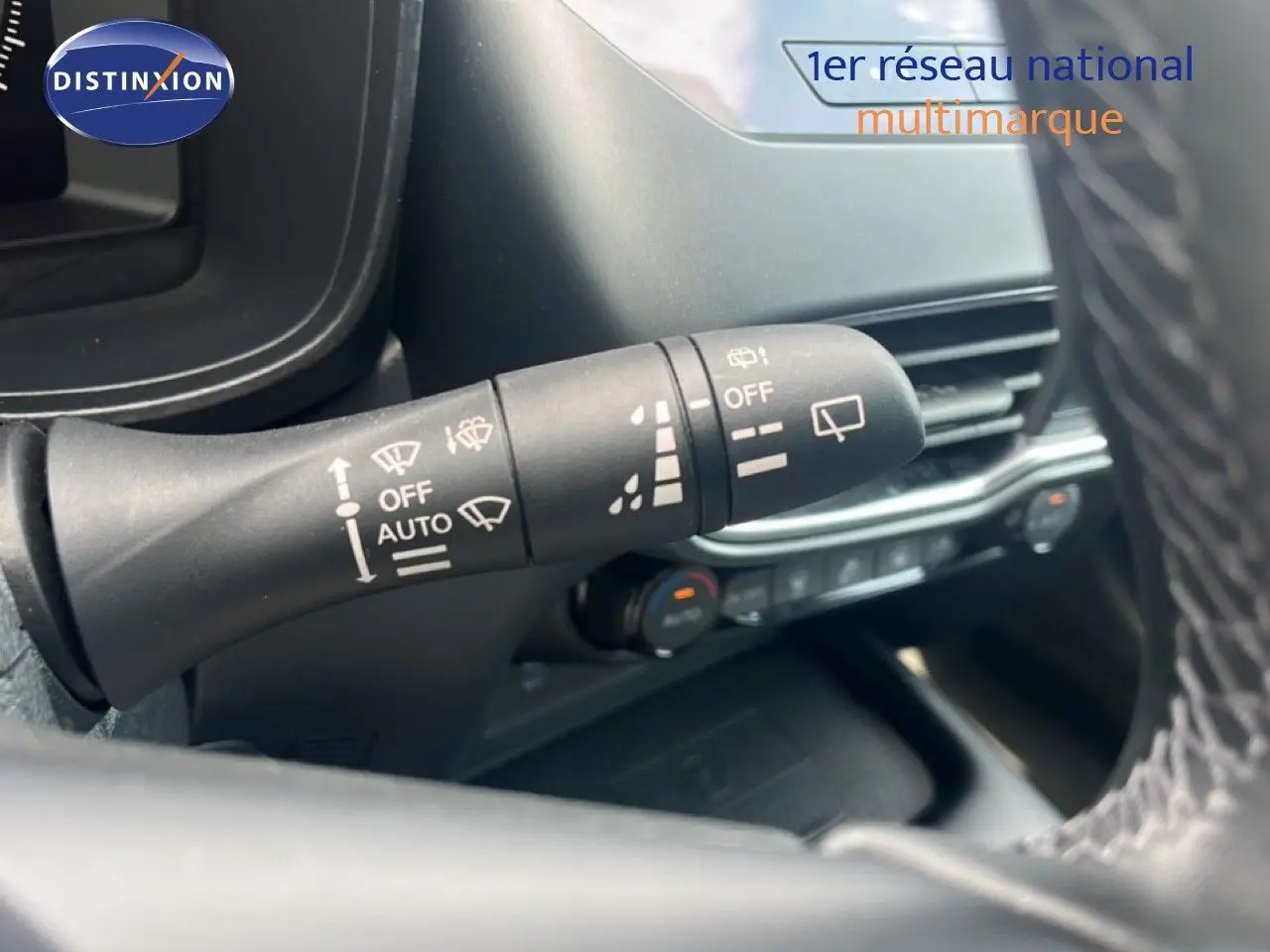 Gros plan sur la manette d'essuie-glace à gauche du volant dans l'habitacle du Nissan Juke rouge Fuji Metal 2024.