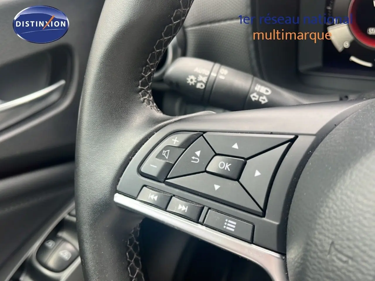 Gros plan sur les commandes au volant noir du Nissan Juke 2024, version DIG-T 114CH N-Connecta.