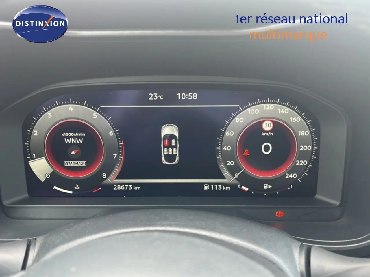 Vue rapprochée du tableau de bord numérique du Nissan Juke rouge Fuji Metal 2024, affichant la vitesse et le compte-tours.