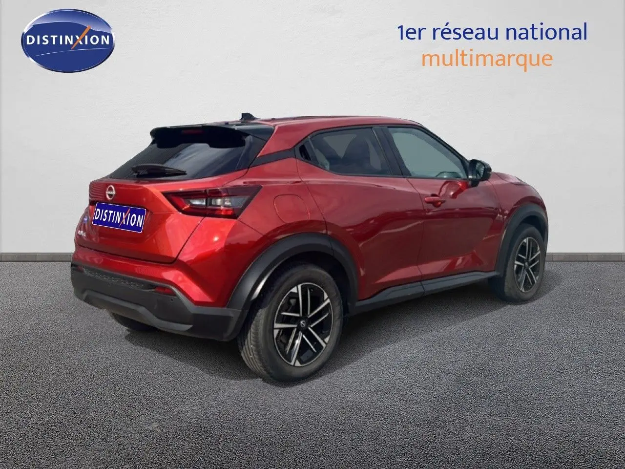 Vue 3/4 arrière droite d'un Nissan Juke 2024 rouge Fuji Metal avec jantes alliage et vitres teintées.