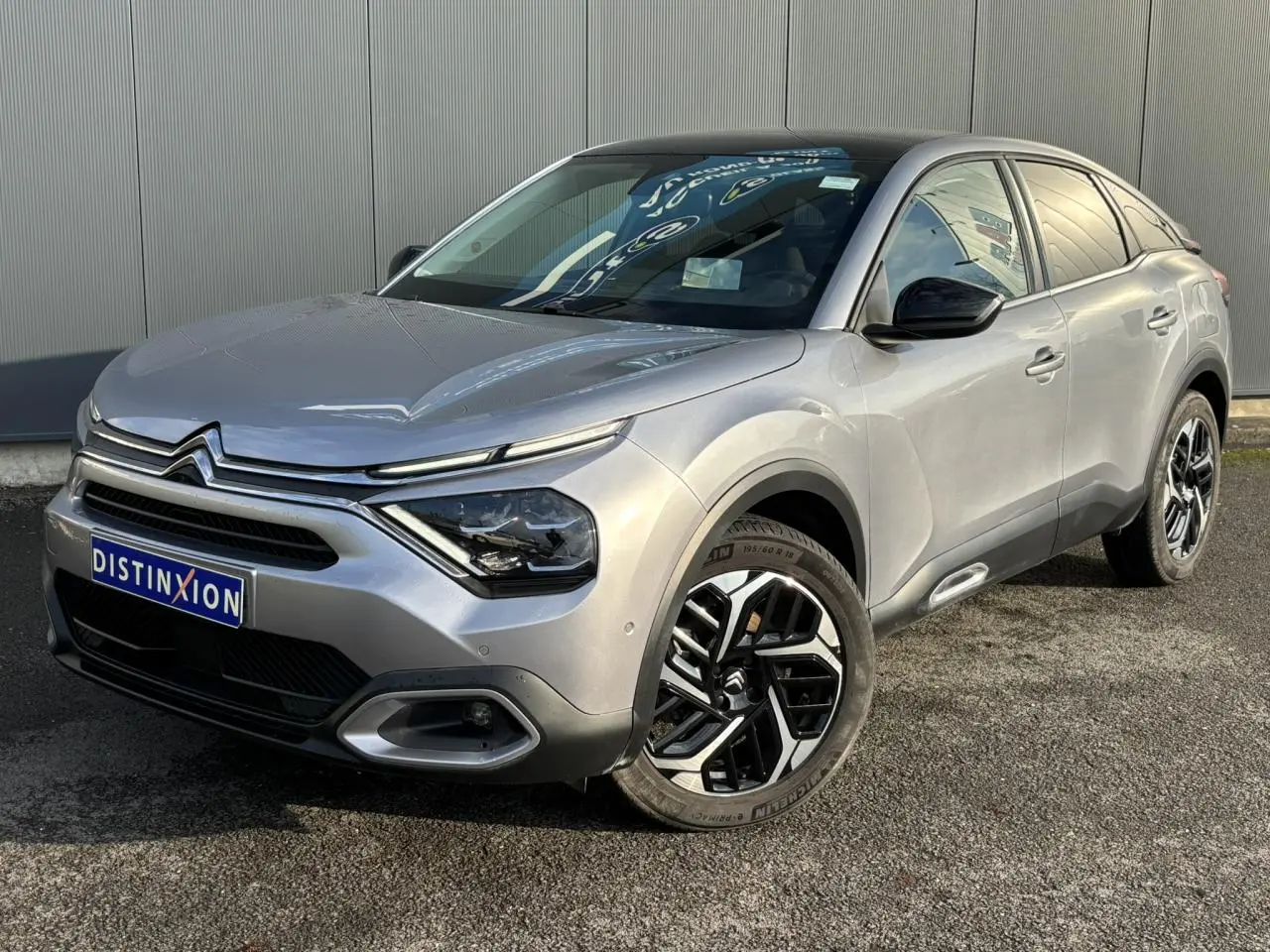 Citroën C4 PureTech 130 gris Artense en 3/4 avant droit avec jantes alliage et toit ouvrant visible.