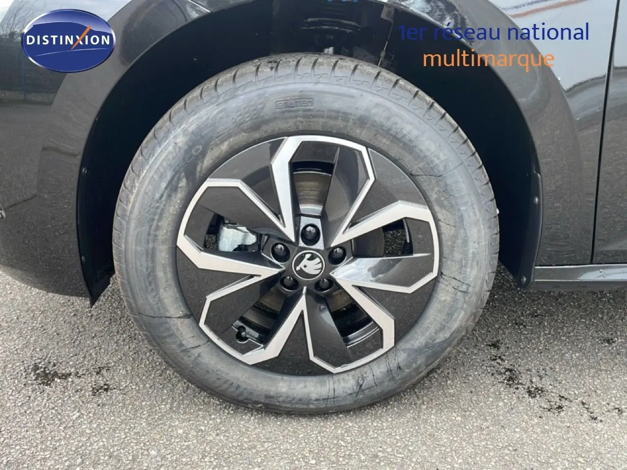 Gros plan sur la roue avant droite d'un Skoda Kamiq noir magique métal avec jante alliage au design géométrique.