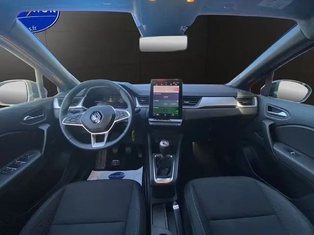 Vue intérieure avant du Renault Captur TCe 90 Evolution 2024, tableau de bord avec écran tactile vertical et volant tissu noir.