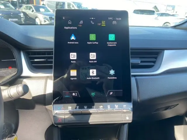 Vue rapprochée de la console centrale du Renault Captur 2024, écran tactile vertical avec interface multimédia visible.