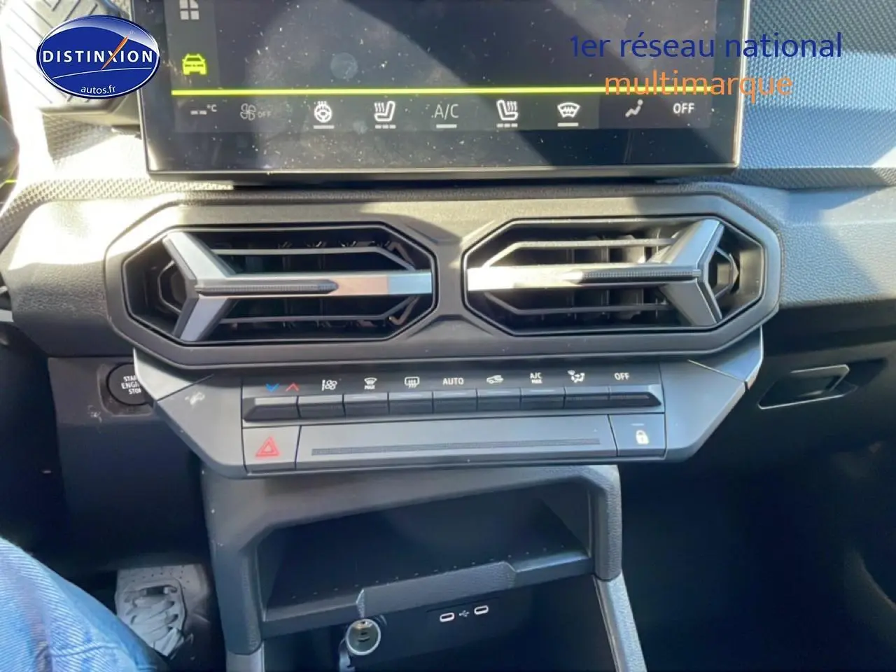 Vue rapprochée de la console centrale du Dacia Duster 2026 noire, montrant les aérateurs hexagonaux et commandes climatiques.