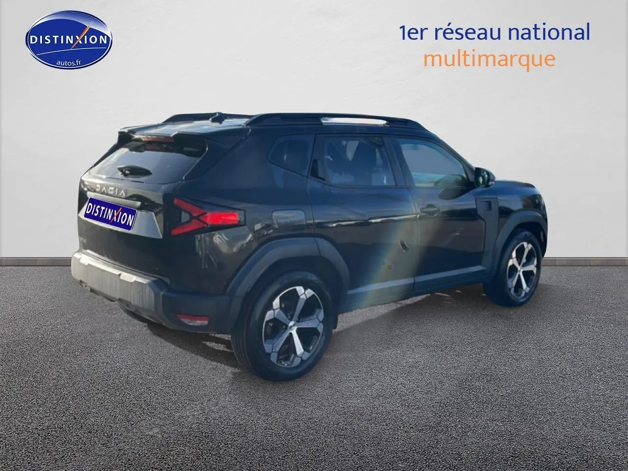 Vue 3/4 arrière droite d'un Dacia Duster noir avec barres de toit et jantes alliage modernes.