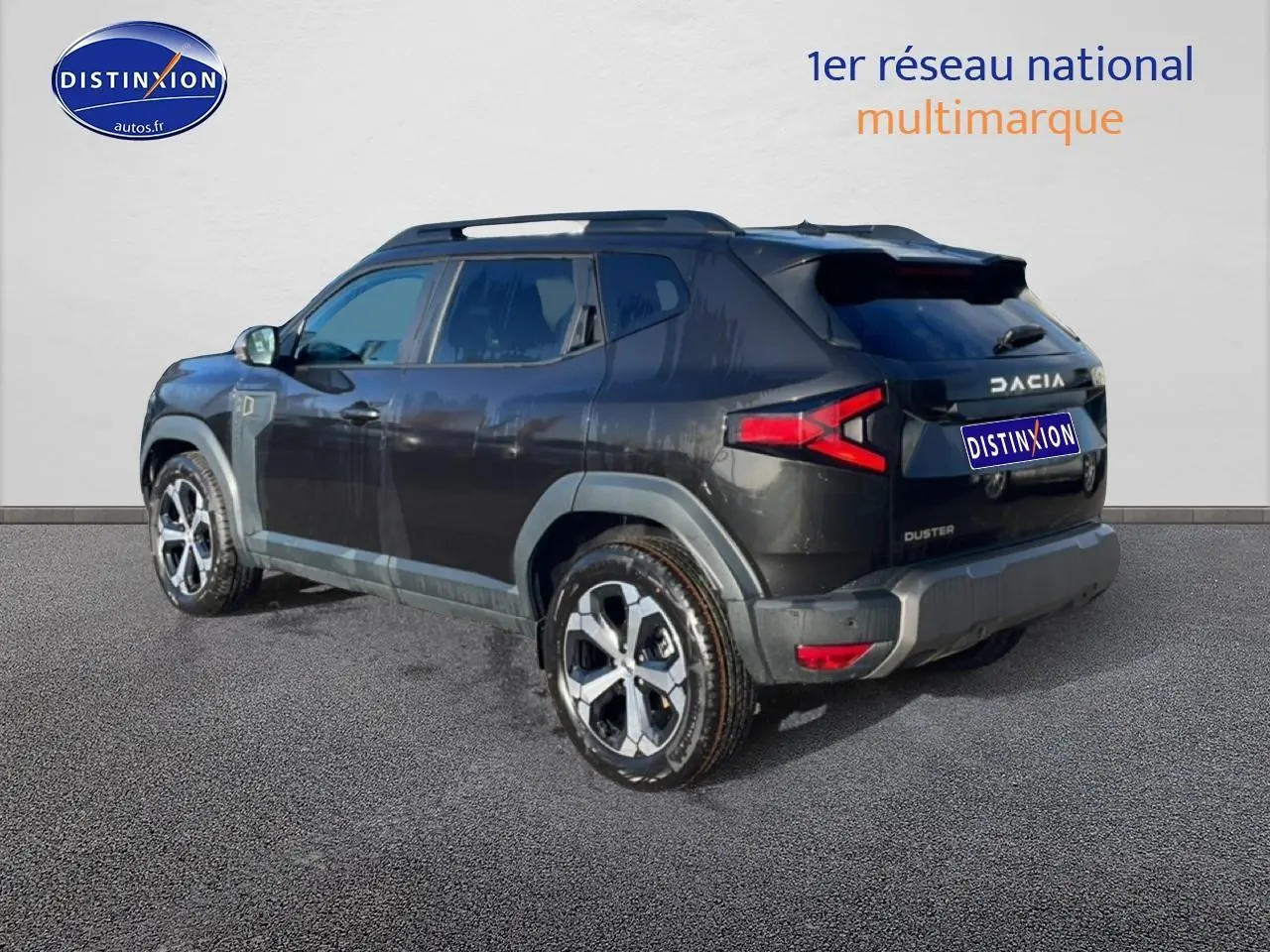 Vue 3/4 arrière droite du Dacia Duster noir 2026 avec jantes alu et barres de toit visibles.