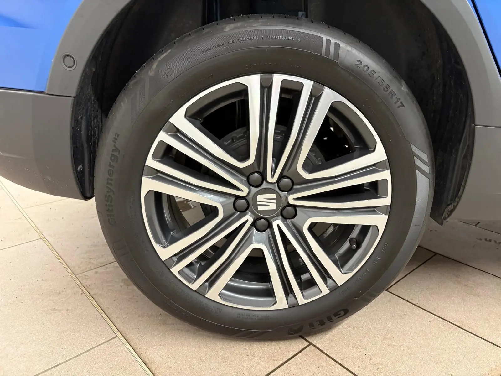 Gros plan sur la jante alliage du côté avant droit d’un SEAT Arona bleu saphir avec toit noir minuit.