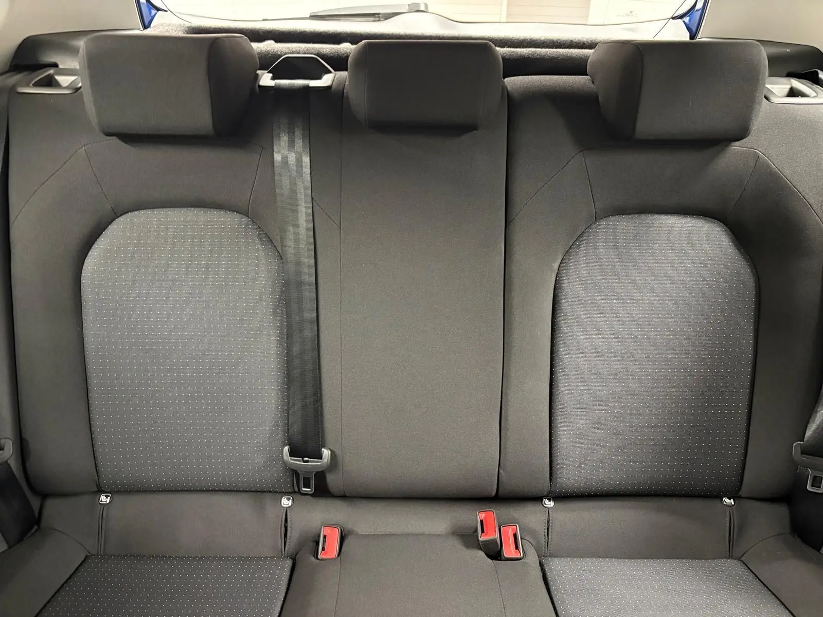 Vue intérieure de l'assise arrière du SEAT Arona 2025, tissu gris foncé avec motifs discrets et ceinture noire centrale.