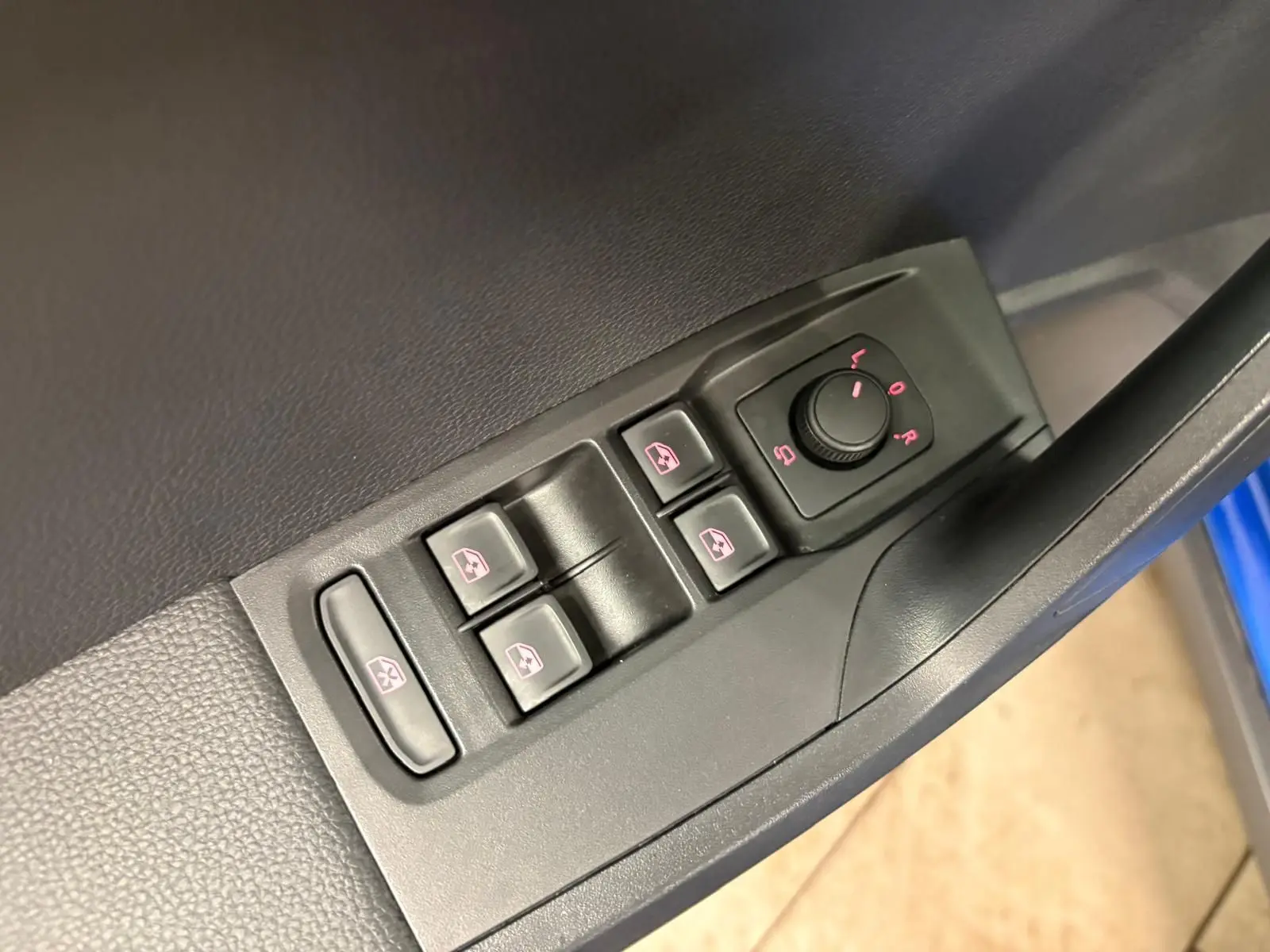 Gros plan sur les commandes des vitres et réglages des rétroviseurs côté conducteur du SEAT Arona Bleu Saphir.