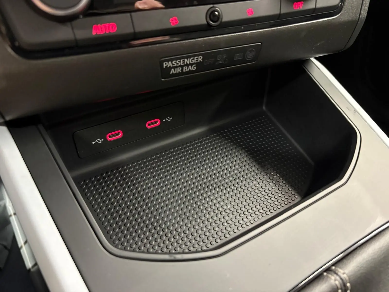 Gros plan sur la console centrale du SEAT Arona 2025, montrant deux ports USB-C avec éclairage rouge et un espace de rangement noir.
